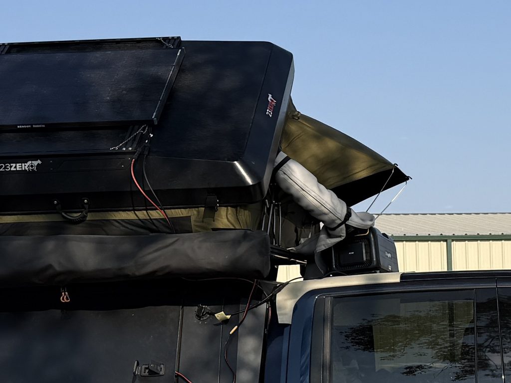 portable a/c on top of truck with vent tube going into rooftop tent. Tube is wrapped with insulation