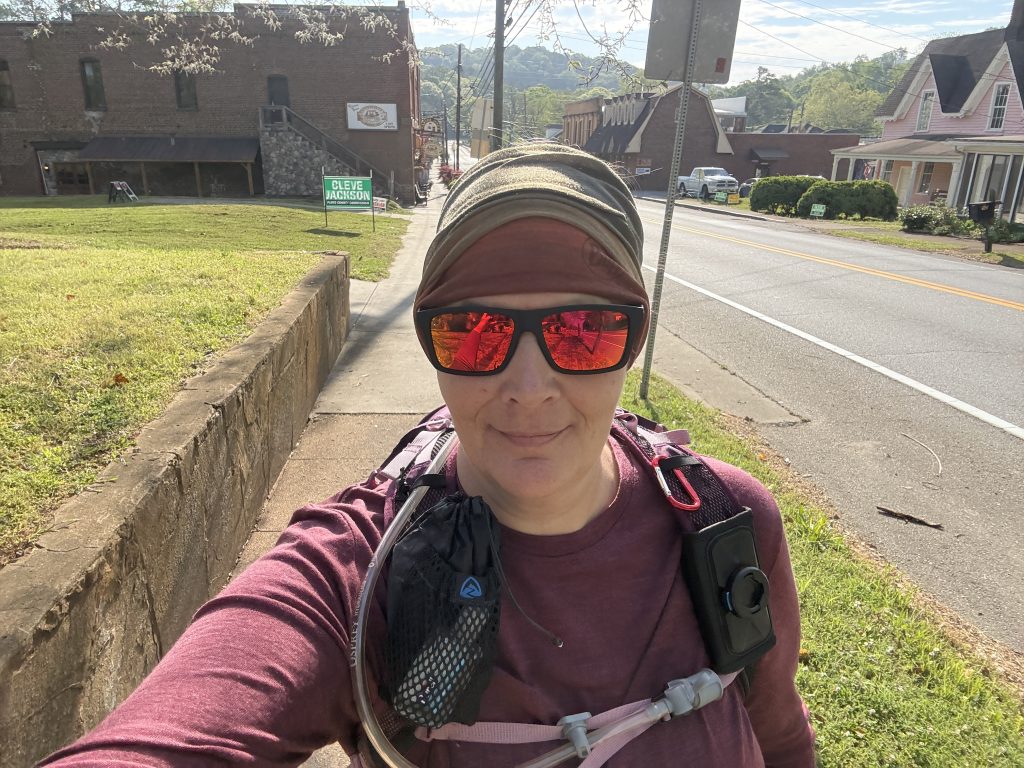 Person walking on a sunny street.