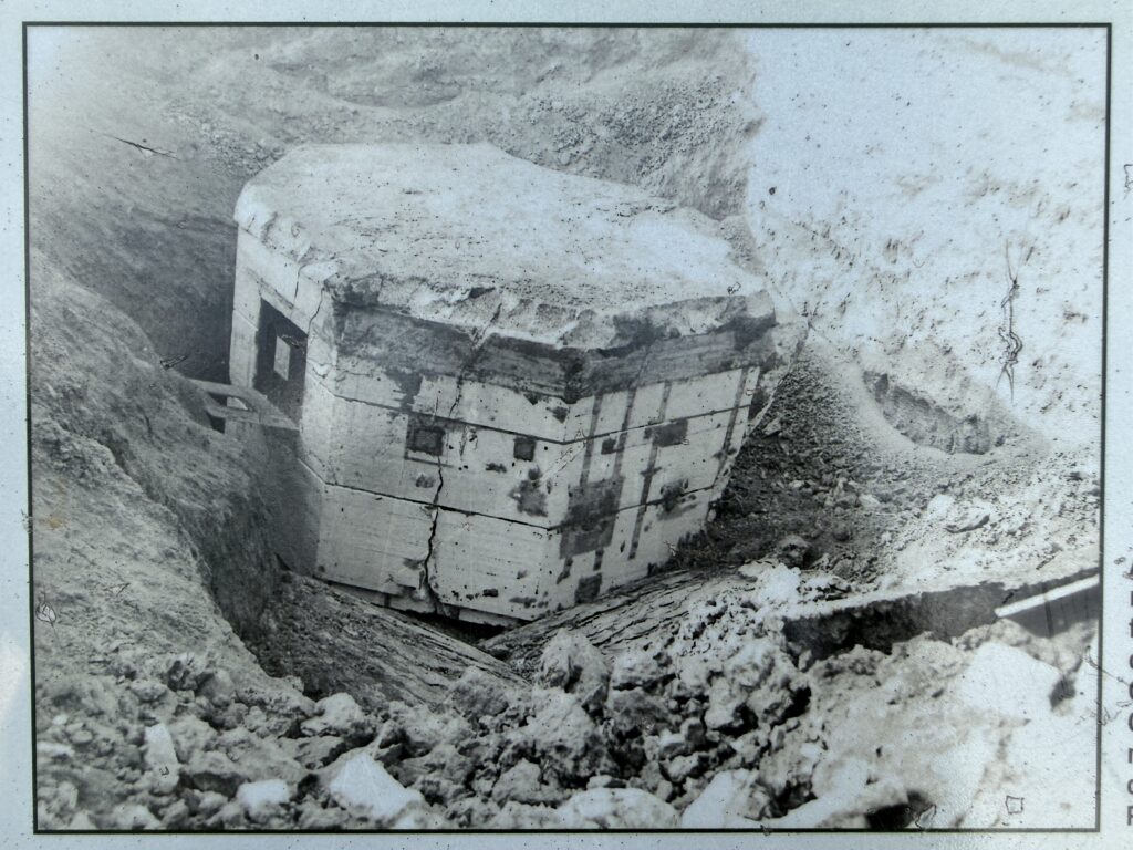 Black-and-white photograph of the CP-2 nuclear reactor encased in concrete and buried in a deep trench.