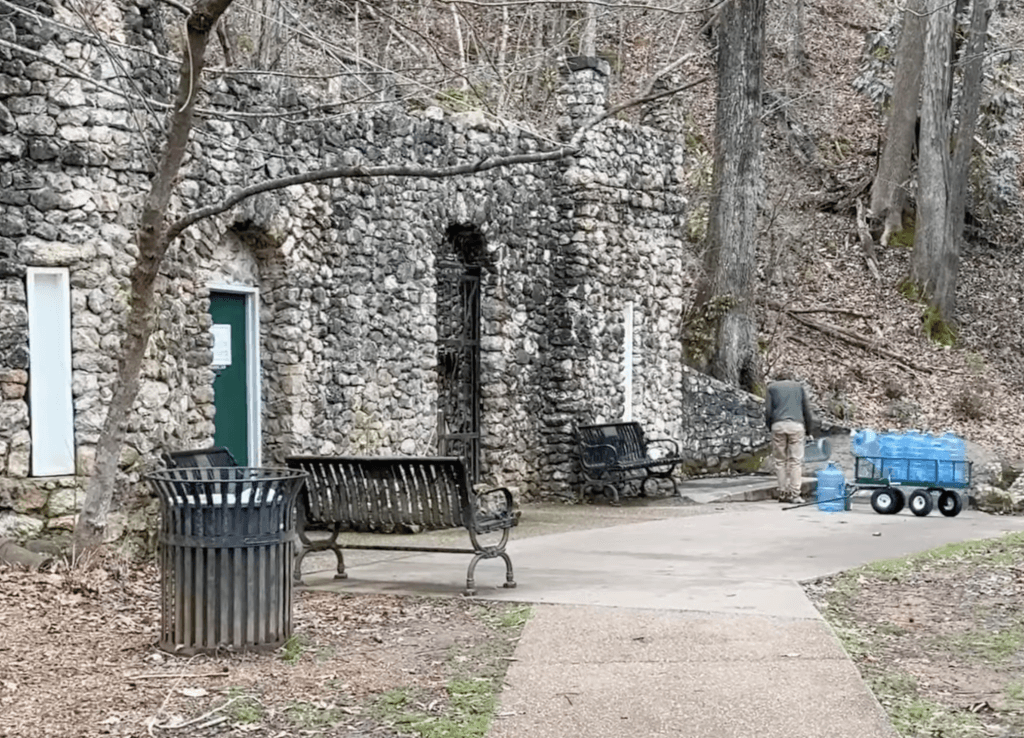 person filling water jugs at the spring in Cave Spring Georgia